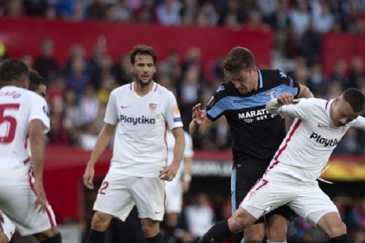 Gelandang Lazio, Sergej Milinkovic-Savic (kaus hitam), berlomba untuk merebut bola dengan pemain Sevilla, Roque Mesa, pada babak 32 besar leg kedua Liga Eropa antara Sevilla FC vs Lazio di Stadion Ramon Sanchez Pizjuan di Sevilla pada 20 Februari 2019. 