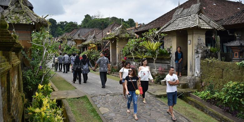 Sejumlah wisatawan mengunjungi Desa Adat Penglipuran di Kubu, Kabupaten Bangli, Bali, Kamis (19/7/2018). Desa yang telah berdiri sejak 700 tahun silam pada masa Kerajaan Bangli tersebut mendapat predikat dari TripAdvisor sebagai desa terbersih sedunia pada 2016 dan saat ini menjadi destinasi favorit wisatawan untuk menikmati suasana perkampungan tradisional adat khas Bali.