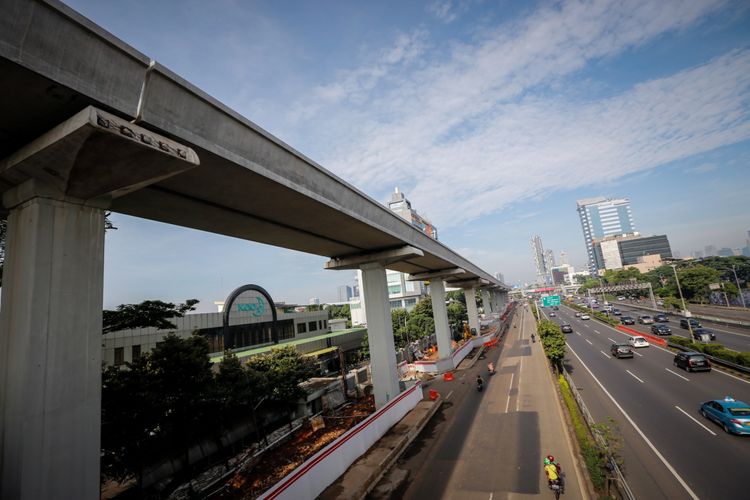 Pengendara melintas di samping lokasi pembangunan Light Rail Transit (LRT) Cawang-Pancoran di Jakarta, Sabtu (24/2/2018). Progres proyek pembangunan kereta api ringan atau Light Rail Transit (LRT) tahap I yang meliputi relasi Cibubur-Cawang, Bekasi Timur-Cawang dan Cawang-Dukuh Atas secara keseluruhan mencapai 20 persen dan ditargetkan selesai pada 2019.