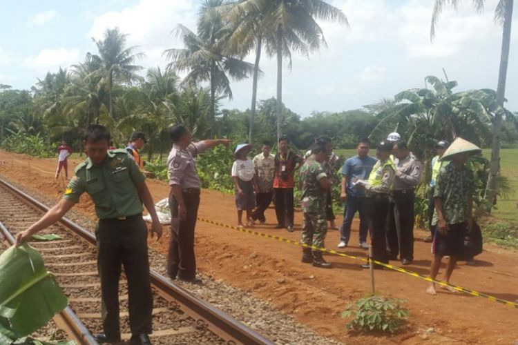 Petugas dari Polsek dan Koramil Kebasen mengamankan jasad korban Dasam Arsanom (61) yang tergeletak mengenaskan di tepi jalur kereta kilometer 366+8/9 Grumbul Menganti, Desa Sawangan RT 2 RW 3 Kecamatan Kebasen, Banyumas, Jawa Tengah, Selasa (31/10/2017).