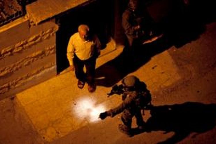 Tentara Israel tertangkap kamera sedang menahan Aziz Dweik, ketua parlemen Palestina yang juga anggota Hamas di kota Hebron, Tepi Barat.