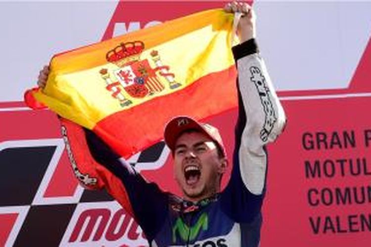 Pebalap Yamaha Movistar asal Spanyol, Jorge Lorenzo merayakan kemenangannya dengan mengangkat bendera Spanyol sebagai juara dunia MotoGP 2015 setelah memenangi GP Valencia, Minggu (8/11/2015).