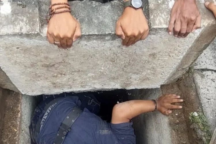 Petugas Damkar yang rela membongkar beton saluran air demi melakukan evakuasi ponsel milik Akhan (19) yang tercebur akibat salah memasukkan ponsel miliknya ke dalam tas. (KOMPAS.com/Dokumentasi Pribadi). 