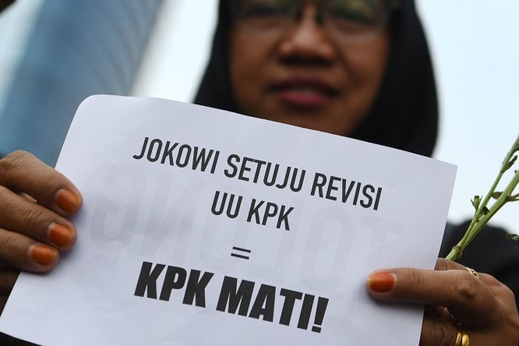 Pegawai KPK membawa bunga dan poster untuk dibagikan kepada warga pada melakukan aksi saat Hari Bebas Kendaraan Bermotor  di kawasan Bundaran HI Jakarta, Minggu (8/9/2019). Aksi tersebut untuk menolak revisi UU KPK yang dianggap melemahkan kewenangan lembaga anti rasuah itu. ANTARA FOTO/Wahyu Putro A/hp.