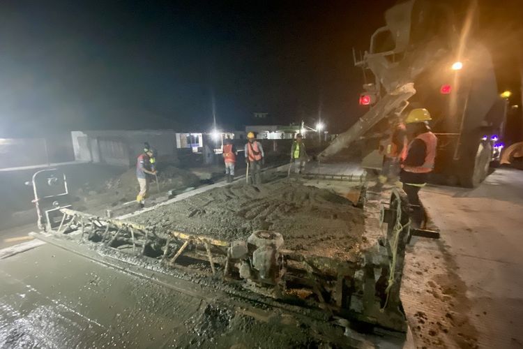 Pekerja konstruksi sedang melakukan pekerjaan perbaikan di Jalan Raman Nirwana, Lampung Tengah, Kamis (26/10/2023) malam.