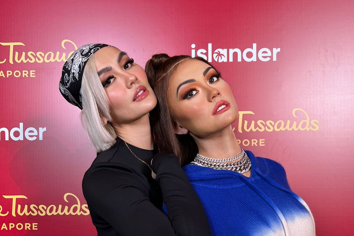 Penyanyi Agnez Mo berpose bersama patung lilin dirinya yang baru diperkenalkan oleh Madame Tussauds Singapura.