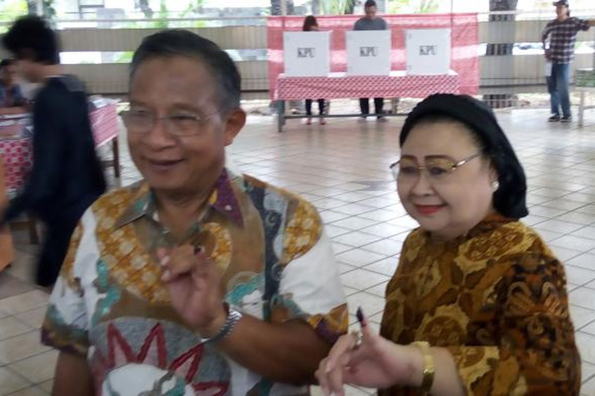 Menteri Koordinator Perekonomian Darmin Nasution bersama istri usai menggunakan hak pilih dalam Pilkada DKI Jakarta 