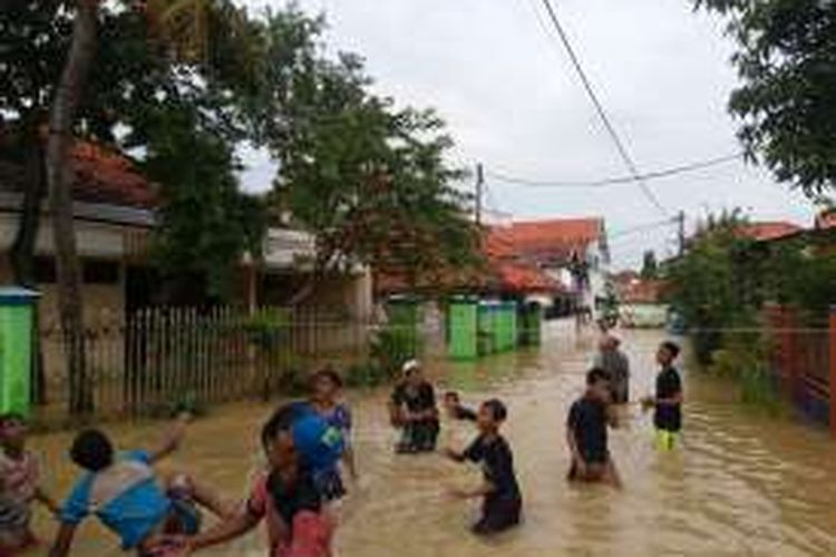 Anak-anak di kelurahan Gunung Sekar bermain bola plastik di tengah-tengah banjir yang belum surut. 