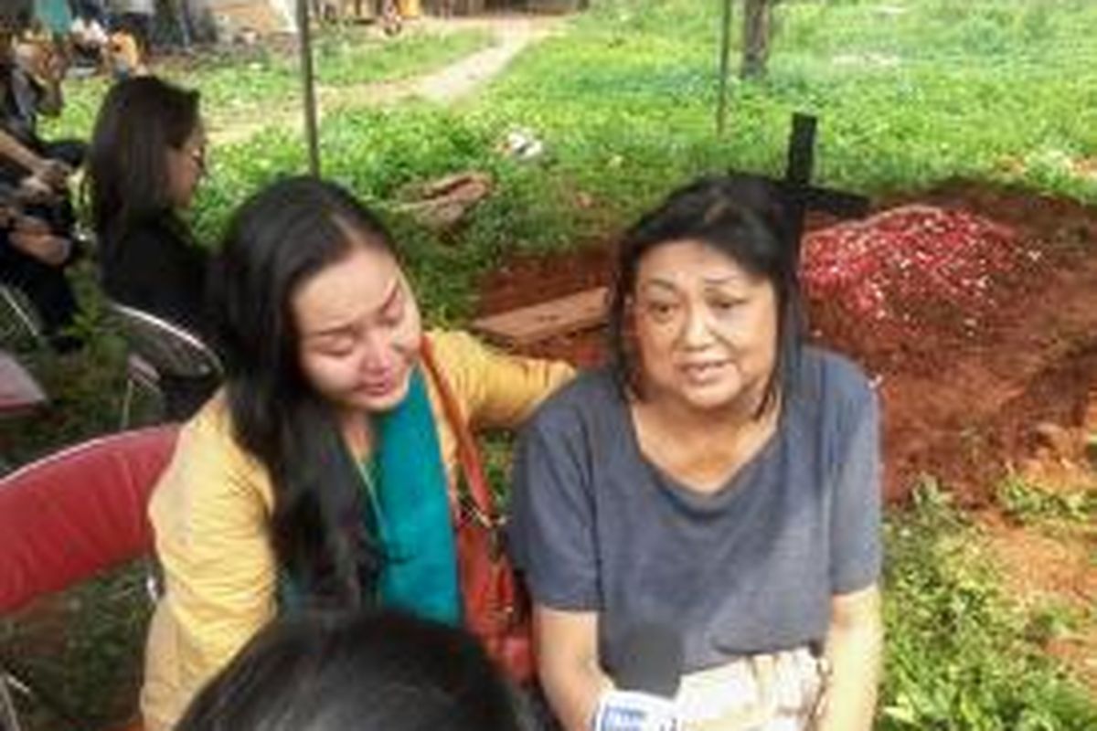 Anna Susanti, ibu Della Caroline (34) didampingi Rere usai pemakaman di TPU Petamburan, Jakarta, Senin (5/8/2013).