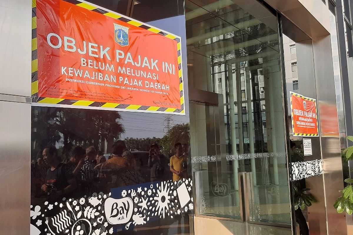 Stiker penunggak pajak dipasang di pintu masuk Mal Baywalk Pluit, Jakarta Utara, yang menunggak pajak sebesar Rp 5,4 miliar, Kamis (5/12/2019).