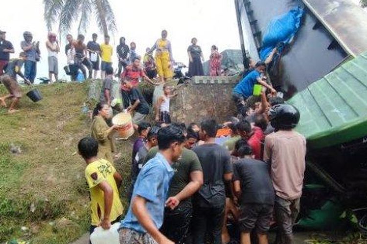 Puluhan masyarakat berbondong-bondong menjarah minyak goreng dari tangki truk pengangkut CPO yang terbalik di jalan lintas Sumatera, tepatnya di Desa Payah Pasir, Kecamatan Tebing Syahbandar, Kabupaten Serdang Bedagai, Rabu (5/7/2023).