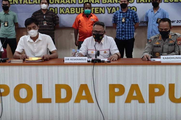 Direskrimsus Polda Papua Kombes Ricko Taruna Mauruh (duduk di tengah) sedang memberikan keterangan pers terkait penetapan dan penahanan mantan Bupati Yalimo Lakius Peyon (berdiri baju oranye) atas dugaan kasus korupsi Dana Bansos, Jayapura, Papua, Selasa (26/10/2021)
