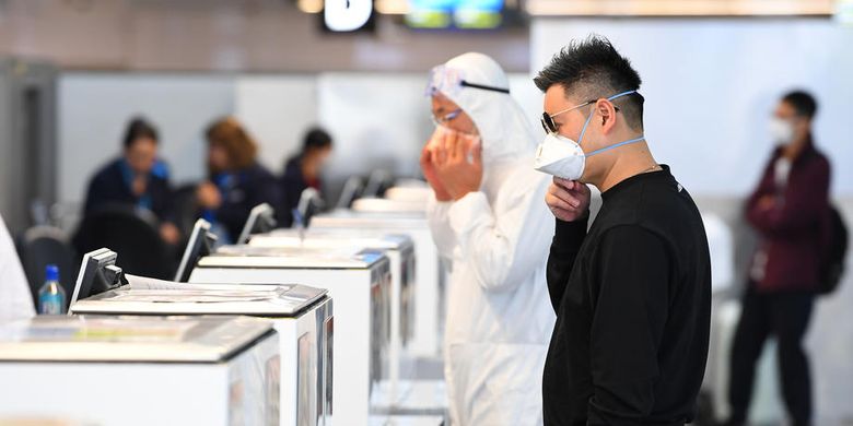 Orang-orang yang memakai alat pelindung diri berdiri di checkin bagasi di dalam terminal keberangkatan internasional di Bandara Melbourne Tullamarine, di Melbourne, Australia, 13 Maret 2020.  EPA-EFE/JAMES ROSS AUSTRALIA AND NEW ZEALAND OUT
