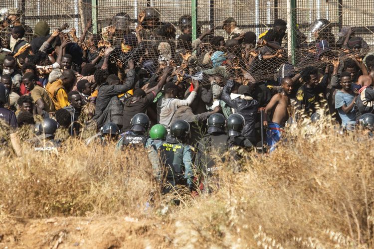 Para migran tiba di tanah Spanyol setelah melintasi pagar yang memisahkan daerah kantong Spanyol Melilla dari Maroko di Melilla, Spanyol, Jumat, 24 Juni 2022. 