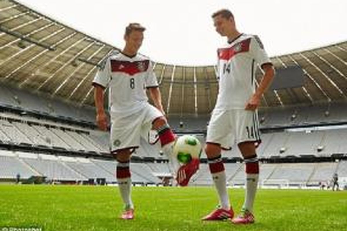 Mesut Oezil dan Julian Draxler saat peluncuran kostum baru tim nasional Jerman di Stadion Allianz, Munchen, Selasa (12/11/2013). Kostum tersebutakan digunakan dalam perhelatan Piala Dunia 2014 di Brazil.