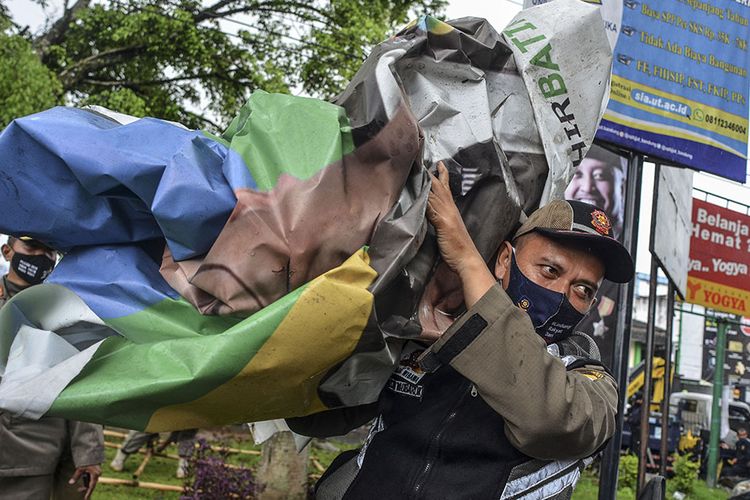 Petugas Satpol PP bersama Bawaslu menertibkan alat peraga kampanye (APK) yang terpasang di Alun-alun Singaparna, Kabupaten Tasikmalaya, Jawa Barat, Selasa (13/10/2020). Penertiban APK pasangan calon Bupati dan Wakil Bupati Tasikmalaya itu karena pemasangan tidak sesuai dengan titik yang ditetapkan dalam peraturan KPU (PKPU).