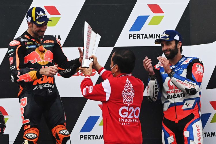 Indonesia's President Joko Widodo (center) presents the trophy to KTM rider Miguel Oliveira, who wins the Indonesia Grand Prix in Mandalika, Central Lombok, West Nusa Tenggara, on Sunday, March 20, 2022 while Johann Zarco who rides for the Pramac Racing team looks on. 