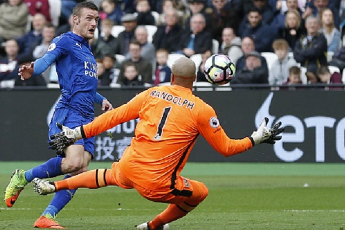 Striker Leicester City, Jamie Vardy, mencoba mengecoh kiper West Ham United, Darren Randolph, pada pertandingan Premier League di Stadion London, Sabtu (18/3/2017). 