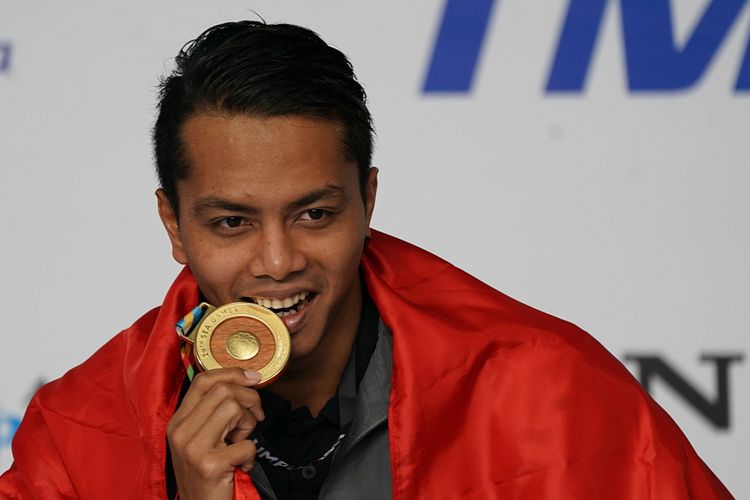 Perenang Indonesia I Gede Siman Sudartawa menggigit medali emas saat menjuarai final renang 50 meter gaya punggung putra SEA Games XXIX di National Aquatic Centre, kawasan Stadion Bukit Jalil, Kuala Lumpur, Malaysia, Senin (21/8/2017) malam. Siman menyabet medali emas dengan catatan waktu 25,20 detik sekaligus memecahkan rekor SEA Games 2015 yang dicatatkan perenang Singapura Quah Zheng Wen dengan 25,27 detik.