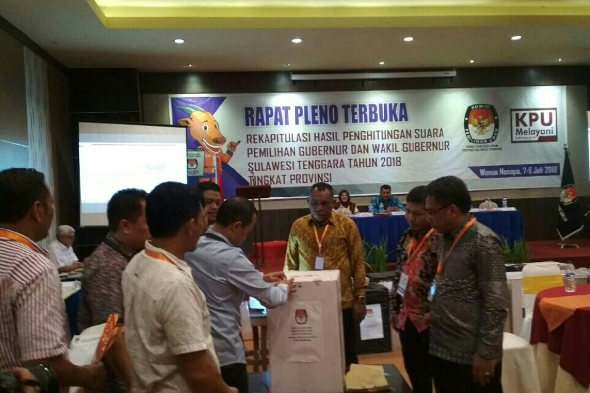 Salah satu anggota KPU Kabupaten dan Panwaslu membuka kotak suara dalam rapat pleno rekapitulasi perolehan suara oleh KPU Provinsi Sultra, Minggu (8/7/2018).