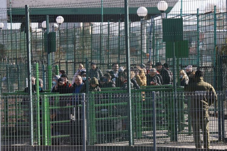 Orang-orang menunggu di sisi Ukraina dari perbatasan yang melintasi antara Polandia dan Ukraina, setelah Presiden Rusia Vladimir Putin mengizinkan operasi militer di Ukraina timur, seperti yang terlihat dari Medyka, Polandia, Kamis (24/2/2022).