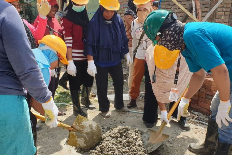 Seorang pelatih (baju biru), memandu dua orang ibu mempraktekkan cara membuat adukan semen untuk pengecoran tiang bangunan rumah, 7 Desember 2019.