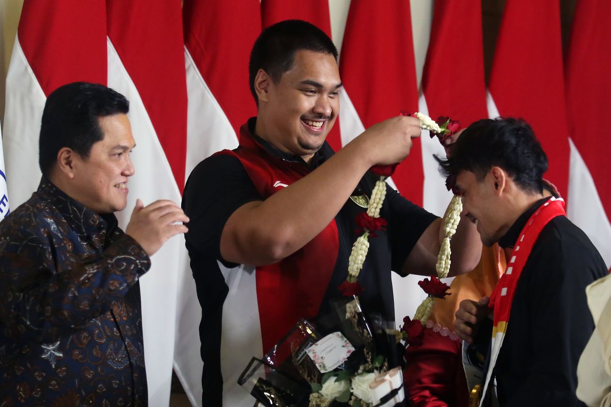 Menpora Dito Ariotedjo (tengah) didampingi IOC Member yang juga Menteri BUMN Erick Thohir (kiri) memberikan kalungan bunga kepada atlet Panjat Tebing Indonesia peraih medali emas di Olimpiade Paris 2024 Veddriq Leonardo (kanan) setibanya dari Paris di Terminal 3 VIP Bandara Soekarno Hatta, Tangerang, Banten, Selasa (13/8/2024). Pemerintah Indonesia berjanji akan memberikan bonus Rp6 miliar untuk atlet peraih medali emas dan Rp1,6 miliar peraih medali perunggu. ANTARA FOTO/Muhammad Iqbal/foc.