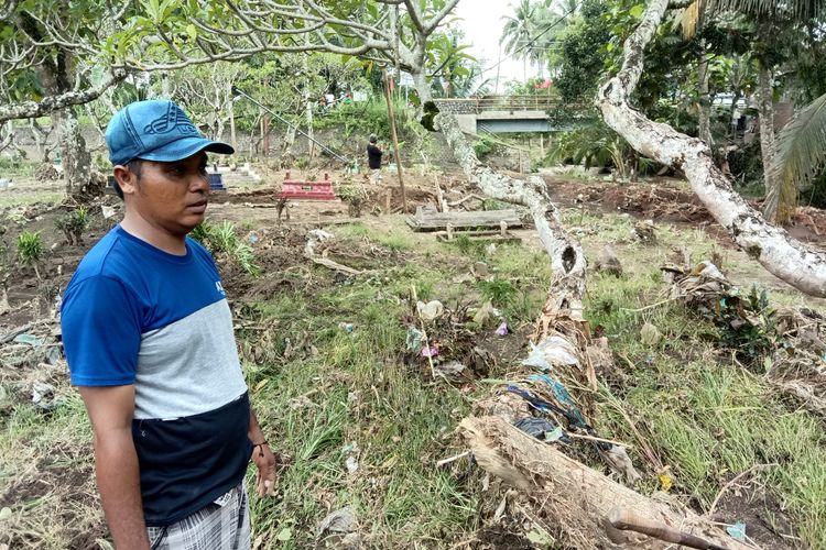 Warga menunjukkan kawasan makam yang rusak diterjang banjir di Banyuwangi.