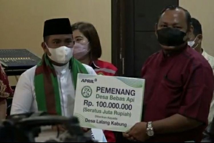 Penyerahan hadiah Rp 100 juta kepada salah satu desa yang berhasil menjaga wilayah dari karhutla di Kabupaten Pelalawan, Riau, Kamis (29/7/2021).