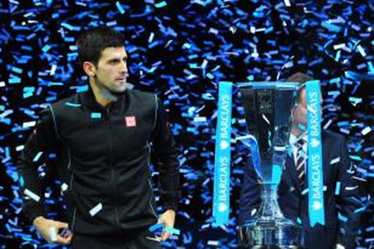 Petenis Serbia, Novak Djokovic berdiri di samping trofi juara ATP Word Tour Finals, setelah mengalahkan Rafael Nadal pada laga final di O2 Arena, Senin (11/11/2013). Djokovic menang 6-3, 6-4.