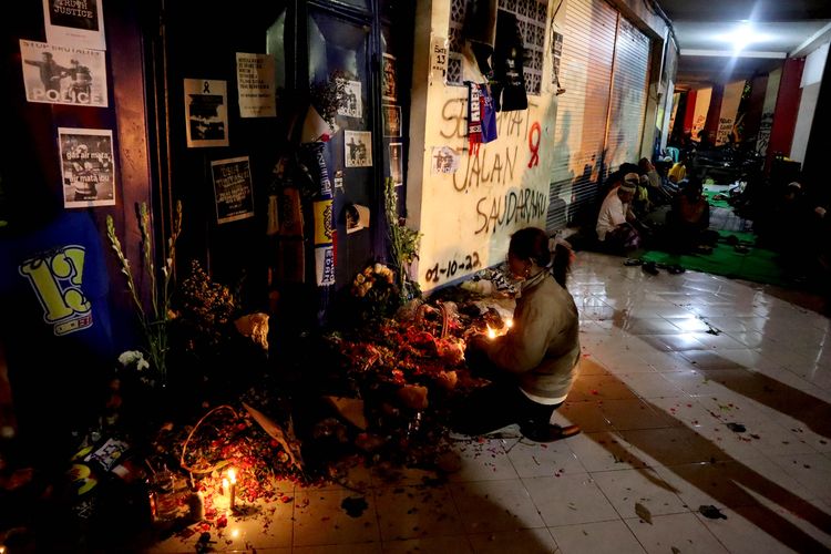 Seorang wanita dan warga melakukan doa bersama di antara gate 12 dan 13 pasca tragedi yang terjadi pada pekan ke-11 Liga 1 2022-2023 seusai pertandingan bertajuk Derbi Jawa Timur, Arema FC melawan Persebaya Surabaya di Monumen Singa Tegar Stadion Kanjuruhan Kepanjen, Kabupaten Malang, Selasa (4/10/2022) malam.