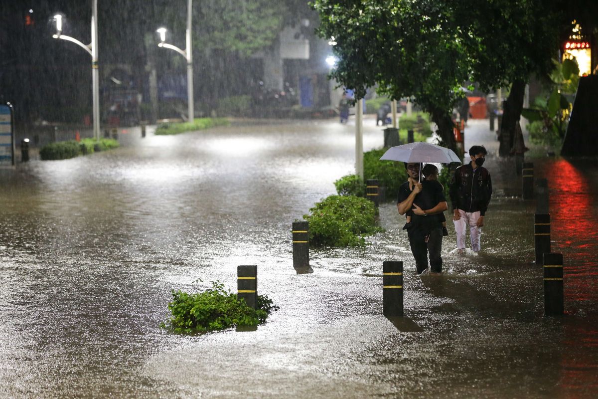 Warga melintasi banjir yang mengenang kawasan Kemang, Jakarta Selatan, Kamis (6/10/2022) malam. Hujan deras yang mengguyur wilayah Jakarta siang menyebabkan Jalan Kemang Raya, Jakarta Selatan, terendam banjir.