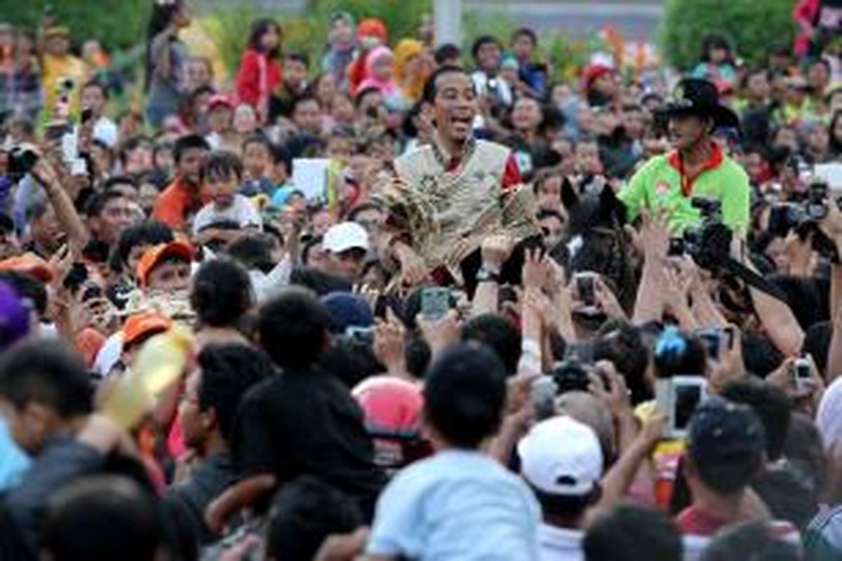 Gubernur DKI Jakarta, Joko Widodo mengikuti arak-arakan Jakarnaval 2013 di kawasan Bundaran Hotel Indonesia, Jakarta, Minggu (30/6/2013). Jakarnaval 2013 yang diikuti sekitar 4500 peserta tersebut sebagai rangkaian peringatan HUT Ke-486 DKI Jakarta.  
