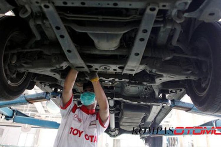 Montir melakukan perbaikkan pada mobil pelanggan di Toyota Astra Motor Sudirman, Jakarta.
