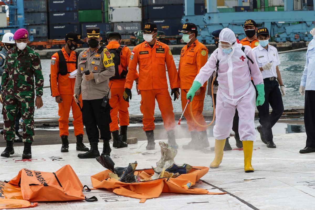 Petugas sterilisasi serpihan pesawat Sriwijaya Air SJ 182 rute Jakarta - Pontianak yang jatuh di perairan Kepulauan Seribu di Posko SAR Sriwijaya Air, Dermaga JICT II, Tanjung Priok, Jakarta, Rabu (13/1/2021).