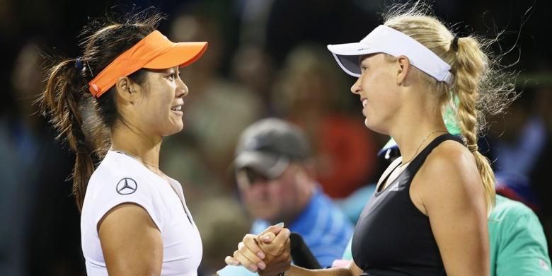 Petenis China Li Na (kiri) bersalaman dengan Caroline Wozniacki dari Denmark usai menyelesaikan laga perempat final Sony Open di Crandon Park Tennis Center, Rabu (26/3/2014).