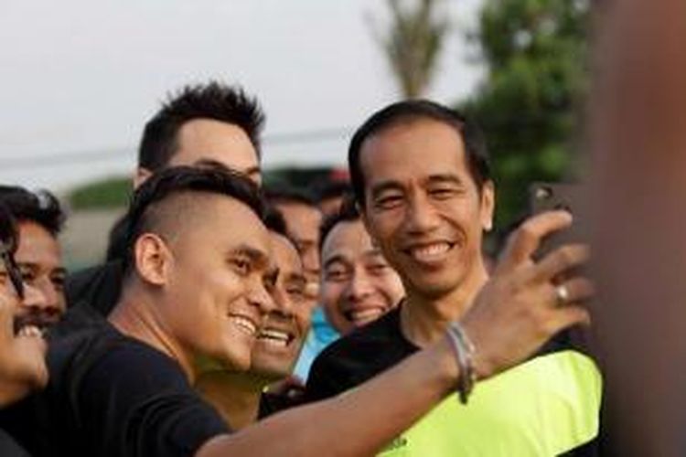 Gubernur DKI Jakarta dan juga Calon Presiden terpilih Joko Widodo alias Jokowi berfoto bersama selebriti saat bermain bola di acara Pesta Rakyat Waduk Pluit, di Lapangan Bola Waduk Pluit, Jakarta Utara, Minggu (17/8/2014). Selain bermain bola, Jokowi juga sempat ikut serta dalam lomba balap karung bersama warga di Taman Waduk Pluit. 