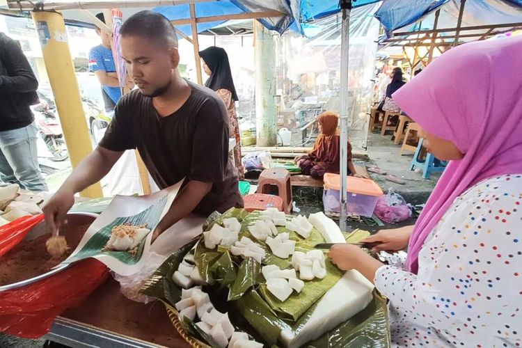 Pegawai H.Mamad saat membungkus ketan bintul di lapaknya di Jalan Maulana Hasanuddin, Pasar Lama, Kota Serang, Banten. Sabtu (23/3/2024). Ketan bintul menjadi makanan kesukaan Sultan Banten dan selalu diburu warga saat bulam Ramadhan.