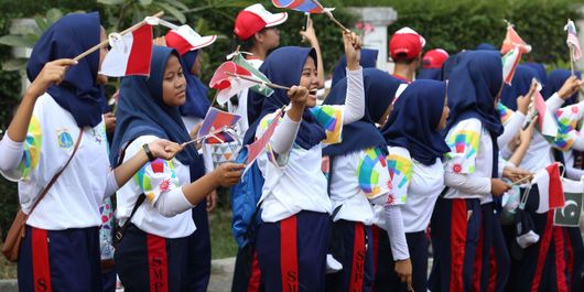 Sejumlah pelajar membawa bendera peserta Asian Games 2018 untuk menyambut Kirab Obor saat Torch Relay Asian Games 2018 di Cilandak, Jakarta Selatan, Rabu (15/08/2018). Api Asian Games akan diarak mengelilingi 5 Kota dan 1 Kabupaten di Provinsi DKI Jakarta