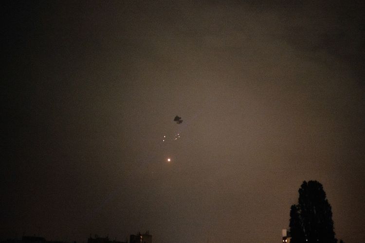 Kepulan asap dan puing terbakar terlihat setelah drone Shahed yang diterbangkan Rusia ditembak jatuh oleh pertahanan udara Ukraina di Kyiv, Minggu (25/5/2025).