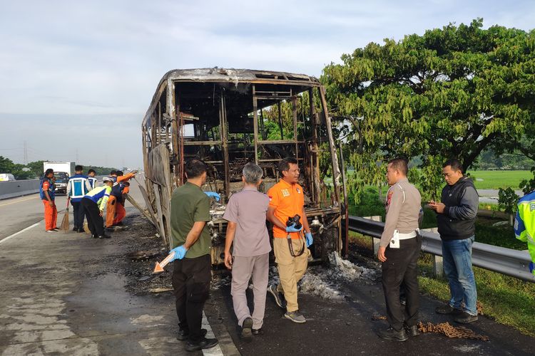 Aparat kepolisian saat melakukan olah TKP kebakaran Bus Cititrans di Tol Nganjuk, Jumat (24/1/2025) pagi