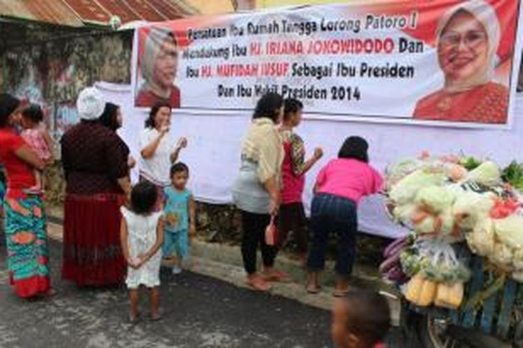 Puluhan ibu rumah tangga di Kendari membubuhkan tanda tangan di spanduk warna putih, sebagai dukungan kepada calon ibu negara dari capres Jokowi-JK. 