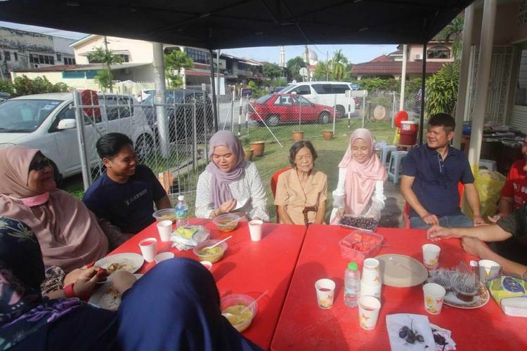 Chee Hoi Lan (tengah) dan Rohana Abdullah (kedua dari kanan) menyambut para tamu pada perayaan Idul Fitri 2022 dan syukuran di rumah mereka di Jalan Ipoh, Malaysia. 