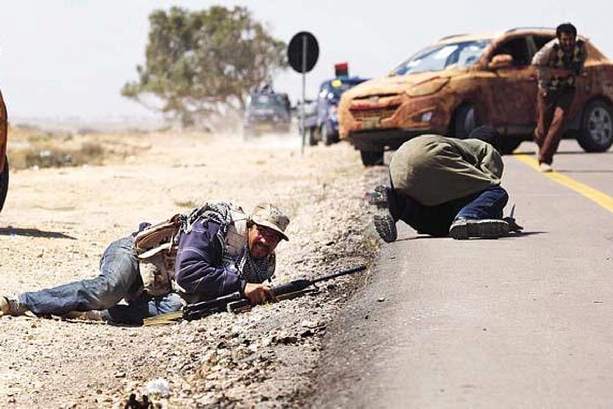 Sejumlah pemberontak Libya tiarap atau mencari perlindungan saat terjadi baku tembak dengan pasukan pro-Khadafy di garis depan, pinggiran kota Brega, Libya, Senin (4/4).