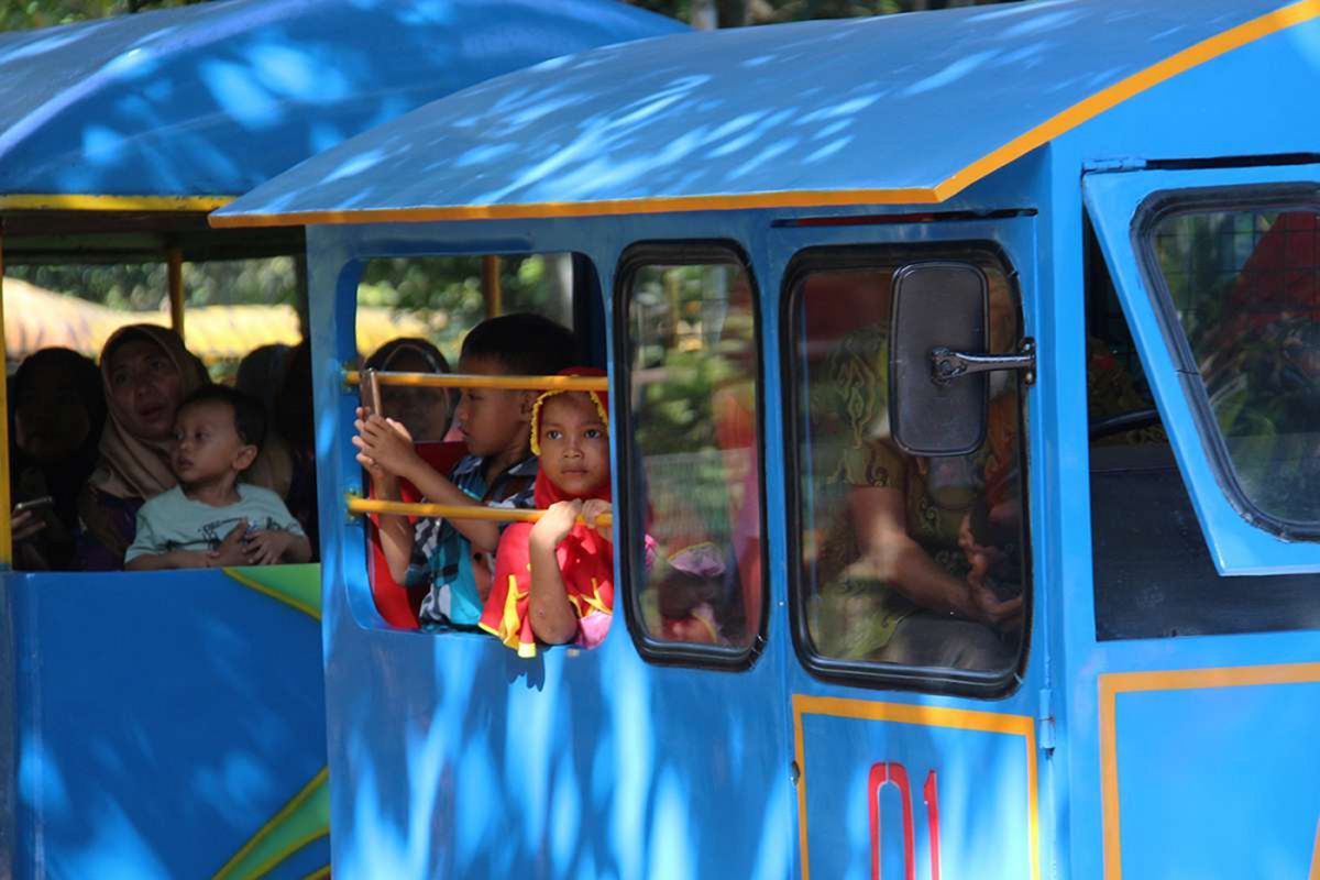 Pengunjung menaiki kereta di Taman Margasatwa Ragunan, Jakarta, saat libur hari raya Natal, Senin (25/12/2017). Tercatat hingga Senin siang, lebih dari 60.000 pengunjung memadati kebun binatang yang kerap dijadikan destinasi wisata saat musim liburan tersebut.