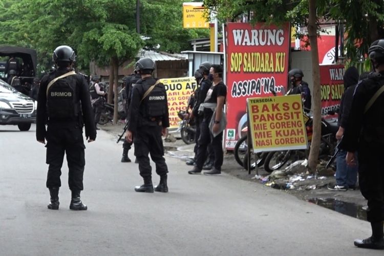 Beberapa petugas dari Brimob Polda Sulsel yang bersenjata lengkap saat mengawal pemakaman terduga pelaku teroris di Makassar, Kamis (7/1/2021).