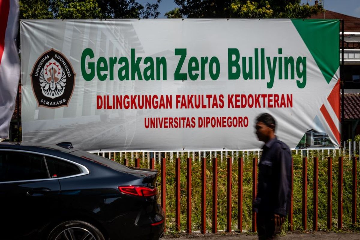 Seorang petugas keamanan berjalan di samping spanduk kampanye Gerakan Zero Bullying yang terpasang di lingkungan Fakultas Kedokteran Universitas Diponegoro (UNDIP), kawasan kompleks RSUP Dr Kariadi, Kota Semarang, Jawa Tengah, Kamis (15/8/2024). Kementerian Kesehatan meminta universitas tersebut menghentikan sementara program studi anestesi di Fakultas Kedokteran menyusul salah satu mahasiswi Program Pendidikan Dokter Spesialis (PPDS) Anestesi berinsial ARL (30) yang meninggal dunia karena bunuh diri, sementara itu kepolisian masih menginvestigasi adanya dugaan perundungan di lingkungan PPDS yang menjadi penyebabnya. ANTARA FOTO/Aji Styawan/aww.