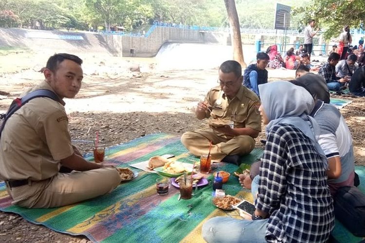 Warga menikmati makanan di pinggir Bendungan Kramat di Batang, Jawa Tengah, Selasa (11/6/2019). 