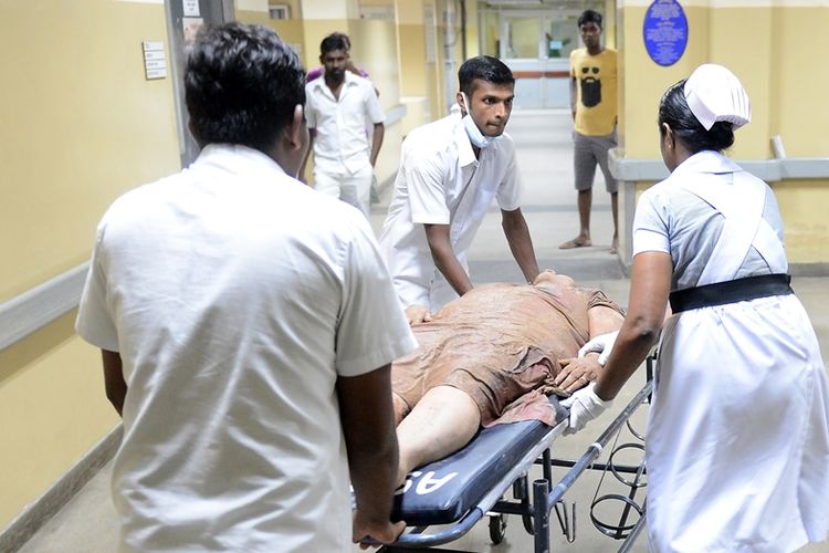 Para staf medis di rumah sakit nasional Kolombo, Srilanka tengah membantu seorang korban runtuhnya gunung sampah setinggi 91 meter ke permukiman penduduk.