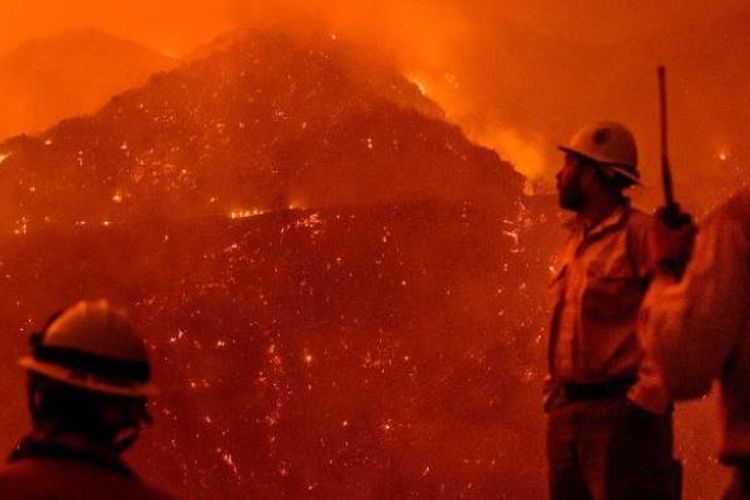 Petugas pemadam kebakaran memantau Api Thomas saat membakar Hutan Nasional Los Padres. (AP via CNN)